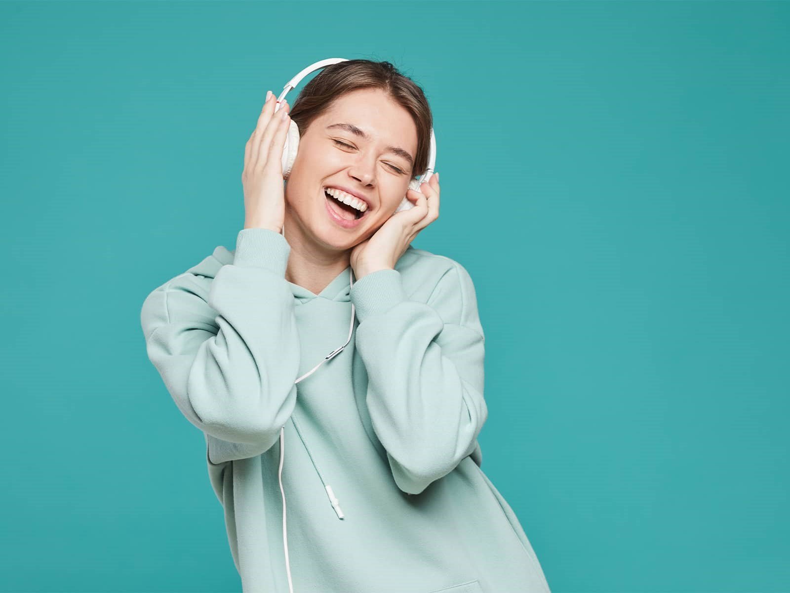Glad kvinde hører musik via fiberbredbånd. Hun er så glad, fordi hendes fiberbredbånd fra EWII er med tilfredshedsgaranti.