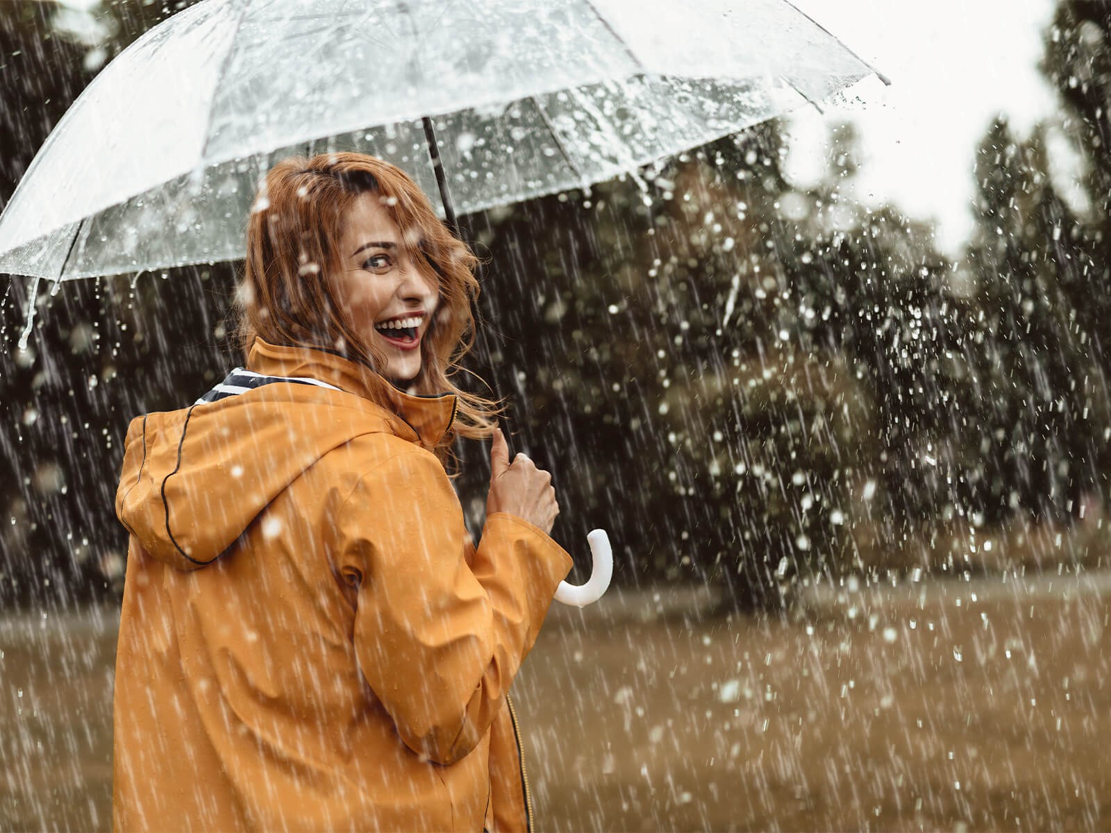 Kvinde med paraply i regnvejr Ansvar for miljøet skal tages alvorligt.