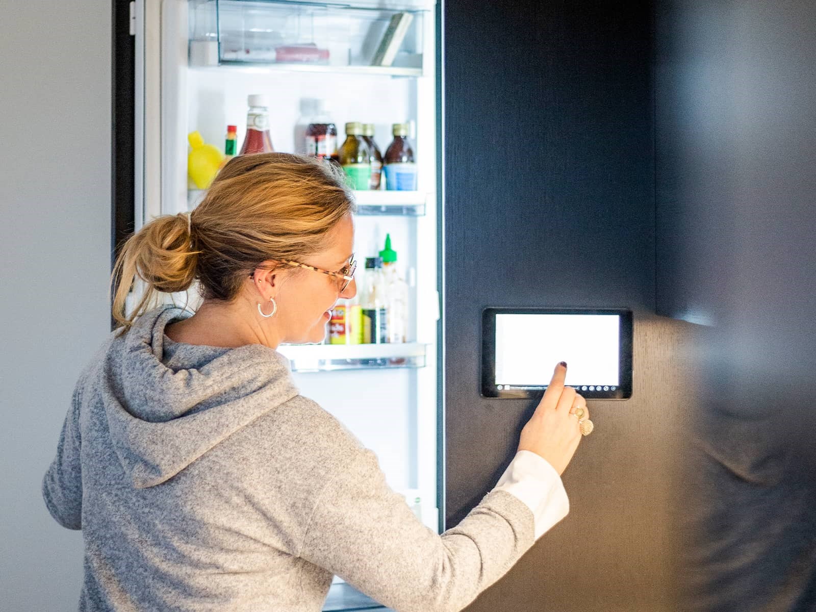 Kvinde med smart køleskab. Fremtiden er elektrisk
